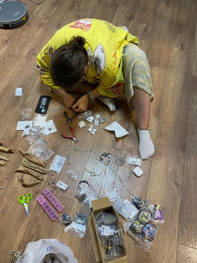 Jewellery assembly spread out on a living-room floor: chains, findings, pliers