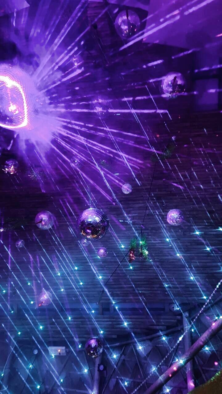Festival ceiling of mirror balls and lasers through haze