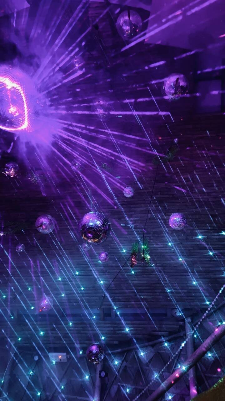 Festival ceiling of mirror balls and lasers through haze