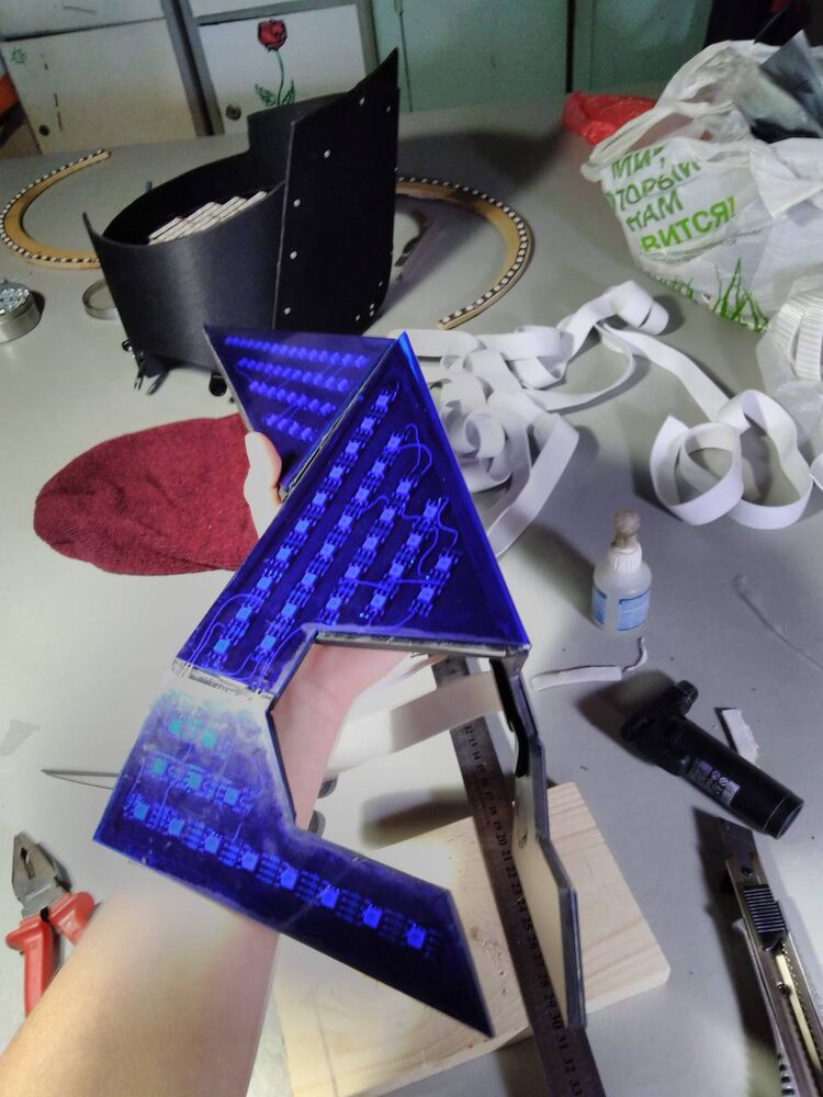 Laser-cut acrylic element lit by addressable LEDs, held in hand