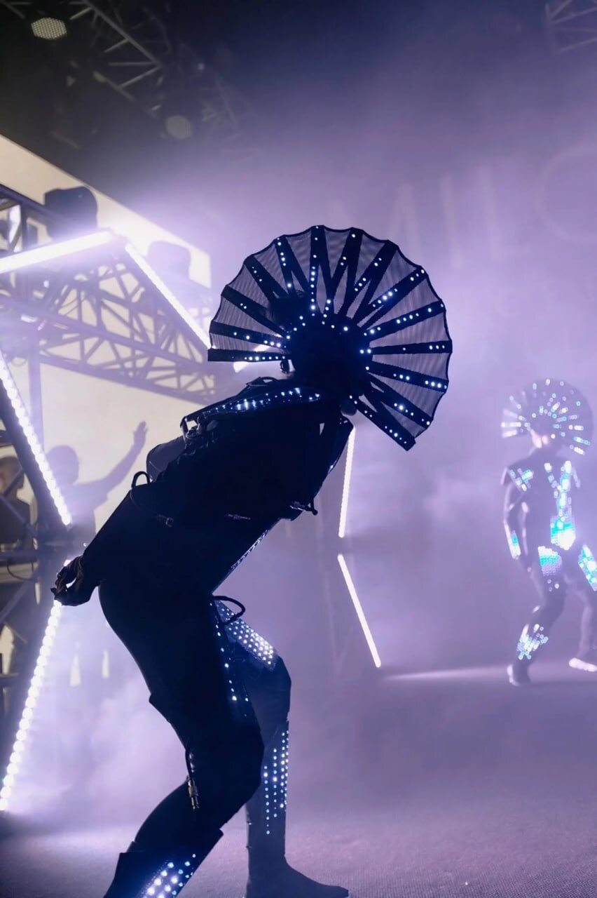 The finished LED fan headdress worn by a dancer on a hazy stage