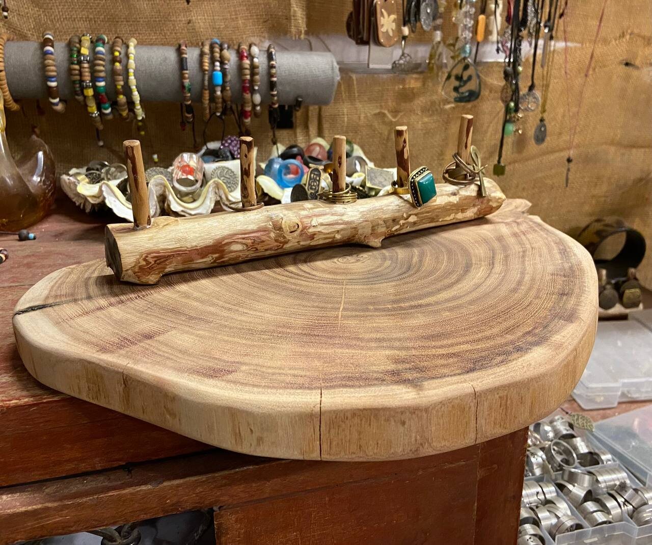 Live-edge wood slab display with a branch ring stand and rings